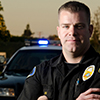 Officer standing in front of police car